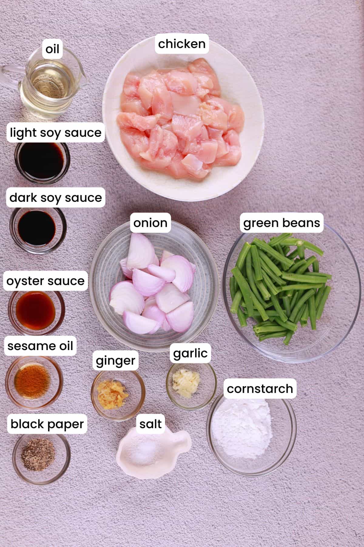 Ingredients laid out for chicken and green bean stir fry including chicken, green beans, garlic, soy sauce, and more.