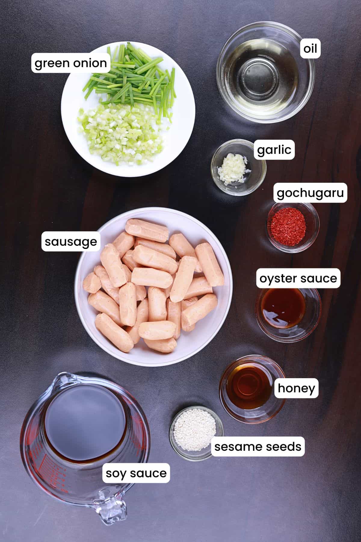 Ingredients for spicy chicken sausage stir fry laid out on a black surface.