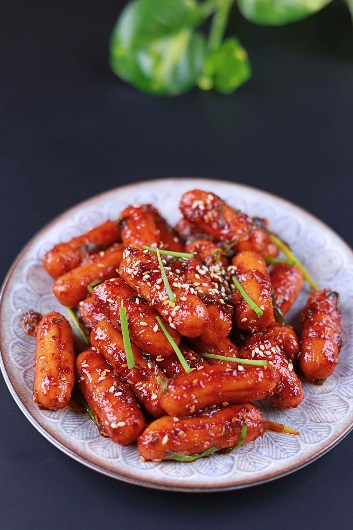 Front view of sweet and spicy sausage stir-fry served on a white plate.