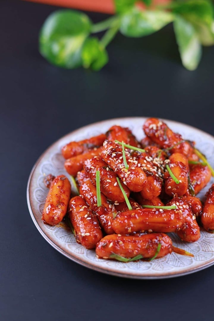 Side view of chicken sausage stir fry coated in a glossy, sweet and spicy sauce.