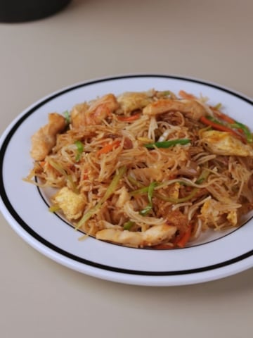 Chinese chicken mei fun home-style noodle recipe served on a white plate.