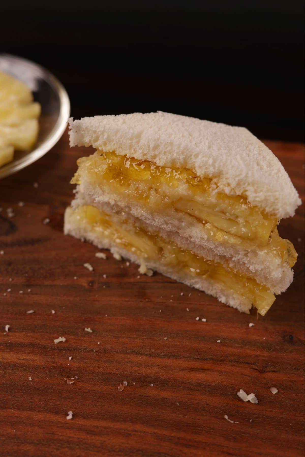 Completing the Pineapple Sandwich: covering pineapple and cheese with bread, then slicing ready-to-serve sandwiches.