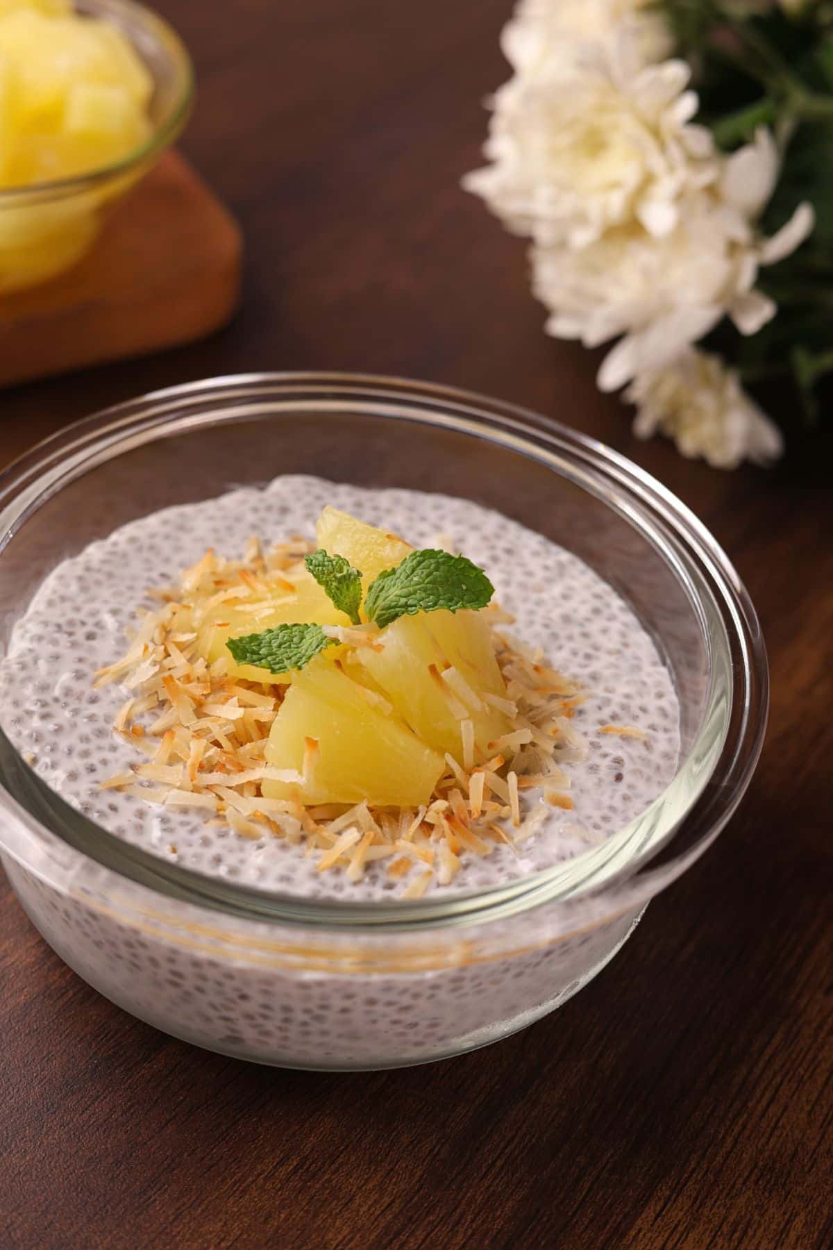 Final coconut chia pudding served in a bowl, topped with pineapple chunks, toasted coconut, and ready to enjoy.