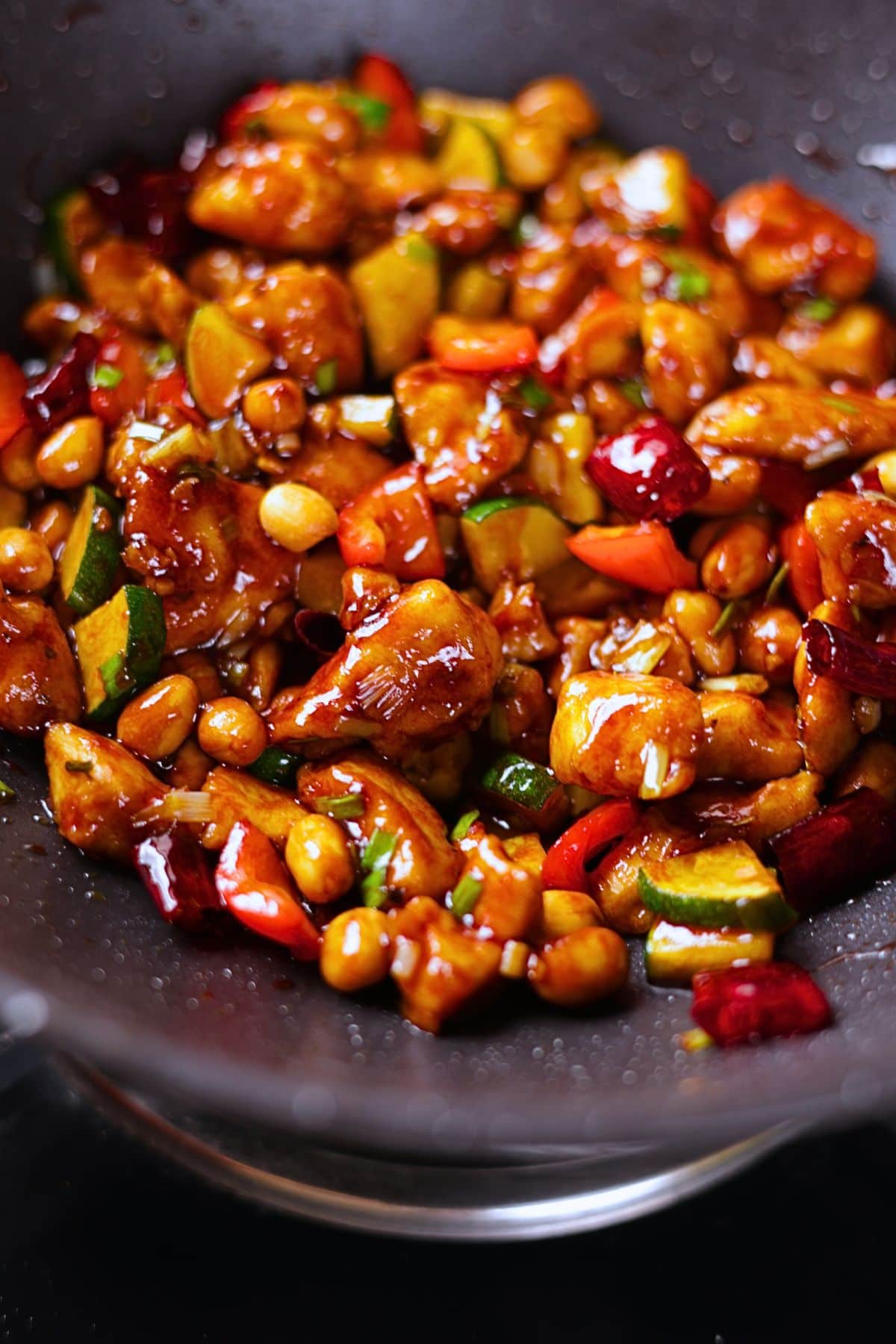 Kung pao chicken quoted in a glossy sauce with peanuts and dried red chilies.
