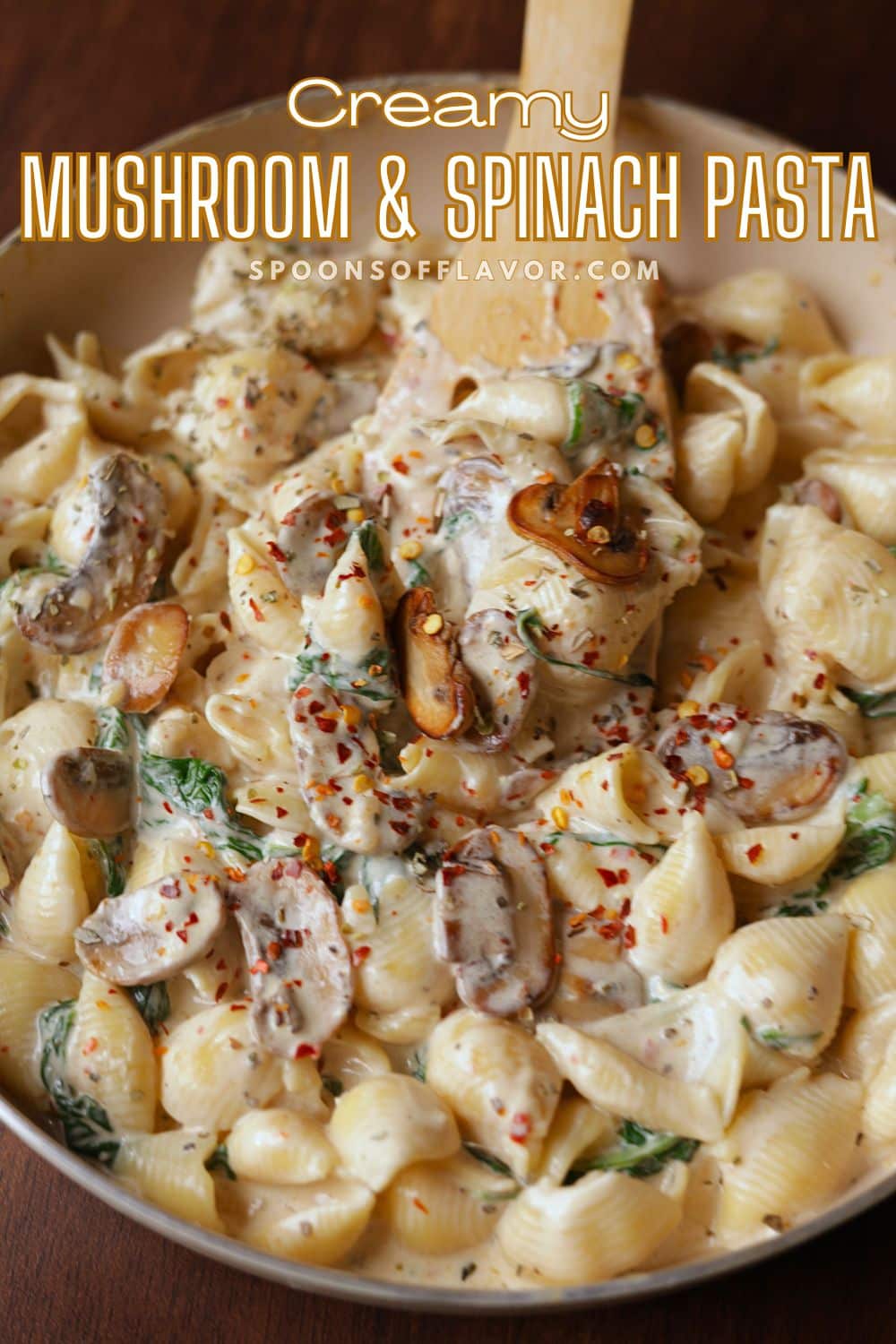 Creamy mushroom spinach pasta in a off white pan.