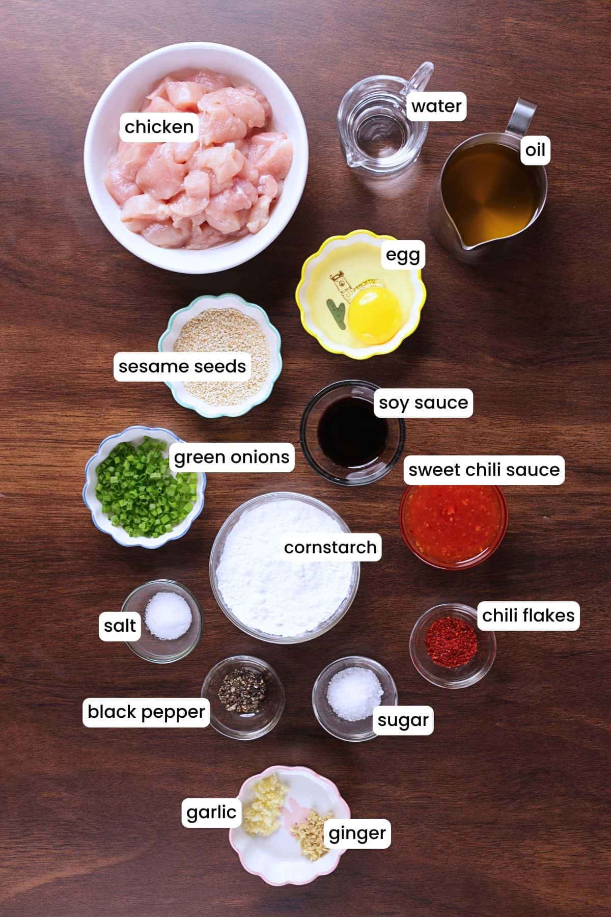 Ingredients for sweet chili chicken laid out on a wooden backdrop.