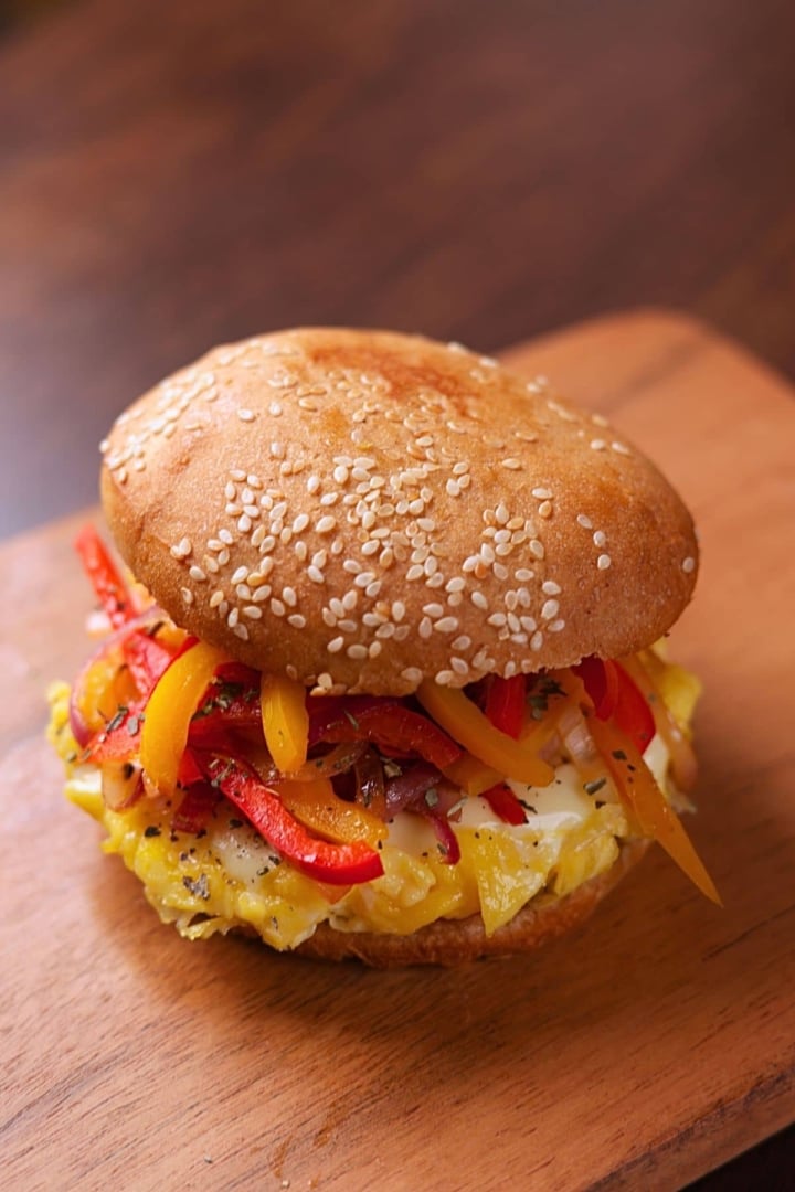 Pepper and Egg Sandwich with soft scrambled eggs, melty cheese, and sautéed peppers and onions on a lightly butter-toasted bun.