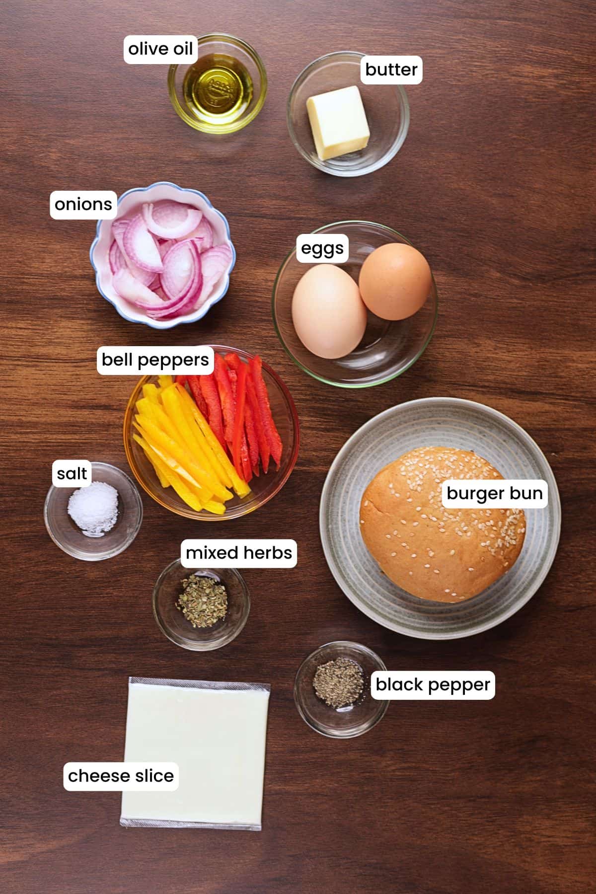 Ingredients for Pepper and Egg Sandwich including eggs, bell peppers, onion, cheese, bread, butter, and seasonings.