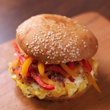 Pepper and Egg Sandwich with soft scrambled eggs, melty cheese, and sautéed peppers and onions on a lightly butter-toasted bun.