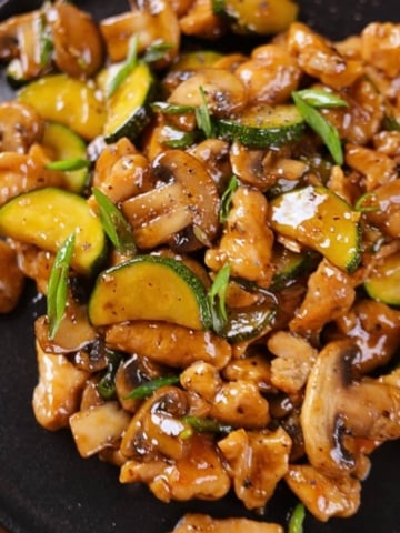 Homemade Panda Express Mushroom Chicken Copycat plated on a black plate.