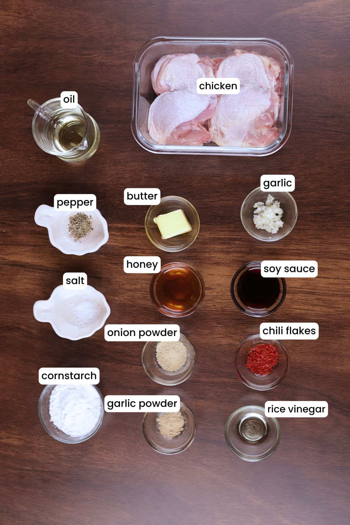Ingredients for honey garlic chicken thighs including chicken, cornstarch, soy sauce, honey, garlic, butter, chili flakes, and rice vinegar.