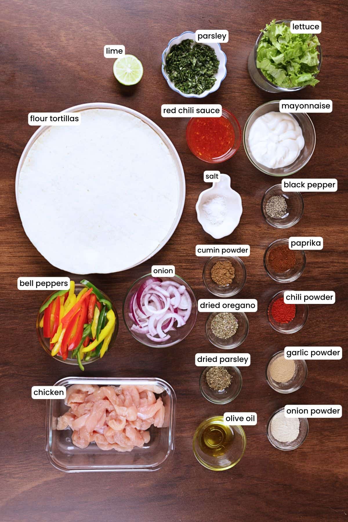 Chicken fajita wrap ingredients including chicken breast, bell peppers, red onion, lettuce, tortillas, seasonings, mayonnaise, and red chili sauce.