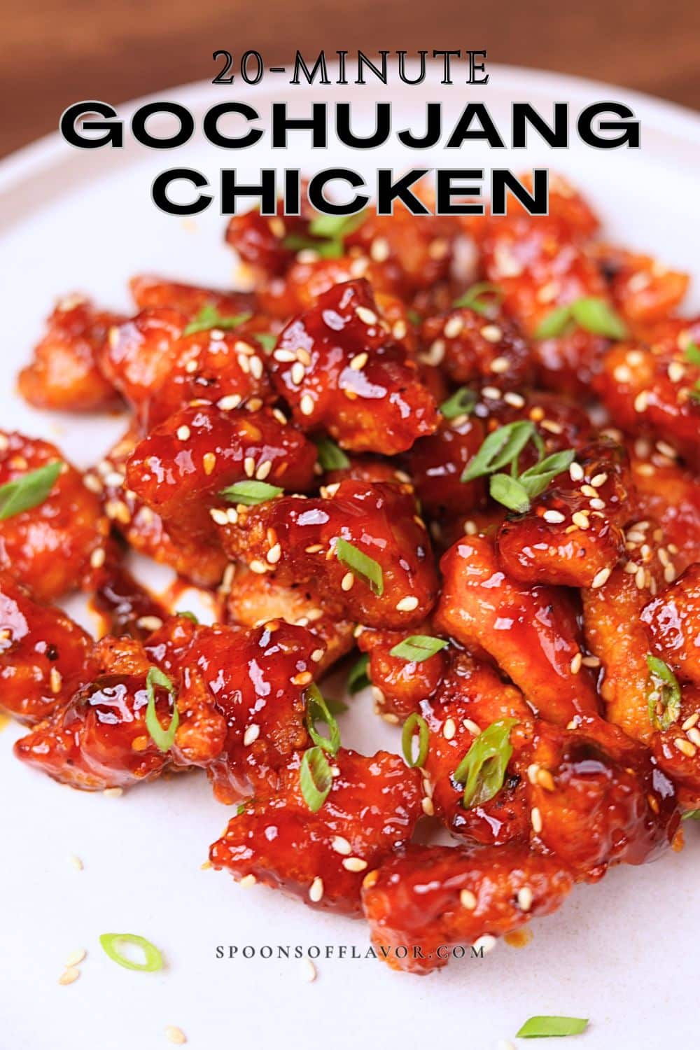 Gochujang chicken garnished with green onions and sesame seeds.