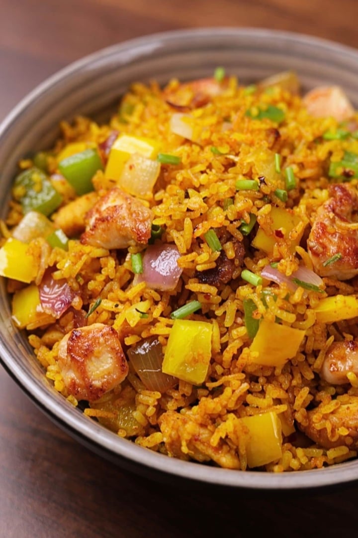 Curry chicken fried rice loaded with tender chicken and crisp veggies served in a bowl.